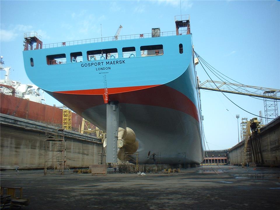 Камера сухого дока с водонепроницаемым бортами и дном, куда заводится докуемое судно при наполнении ее водой. Контейнеровоз Gosport Maersk на стапельных тумбах.